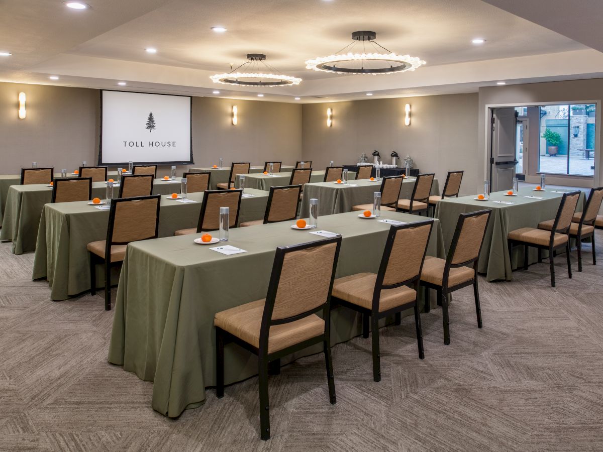 The image shows a conference room setup with tables, chairs, and a projector screen displaying 